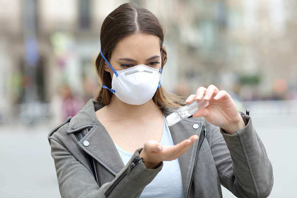 A young girl applying sanitizer in his hand