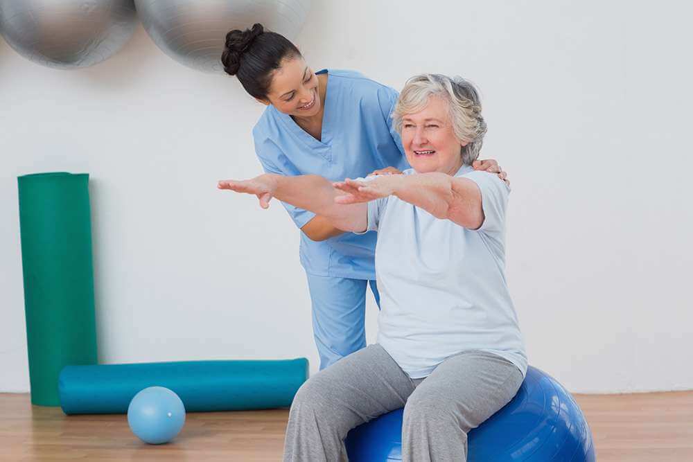 physical therapist helping senior woman in exercise