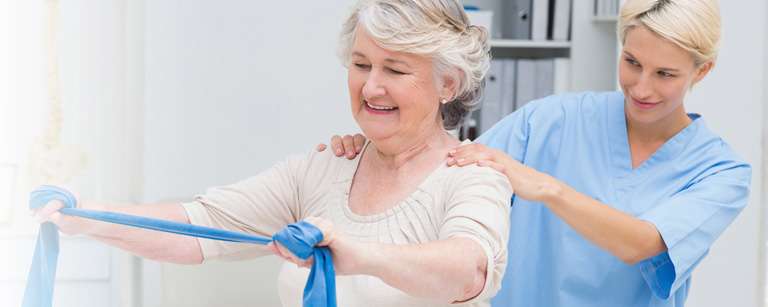 Therapist helping woman in exercise