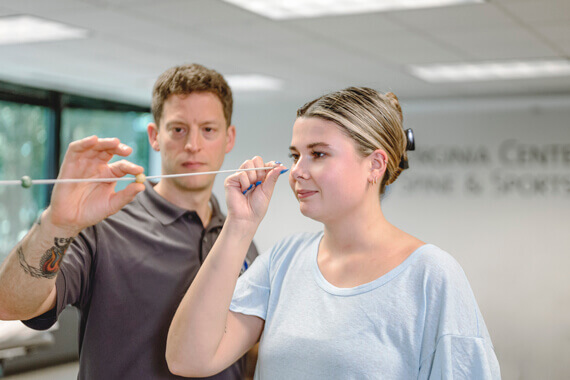 physical therapist and female patient holding little balls 