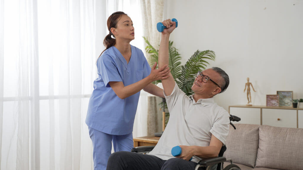 Senior Man is holding up dumbbells for rehab training at home