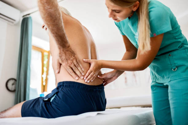 Attractive young female physiotherapist working with a senior male patient