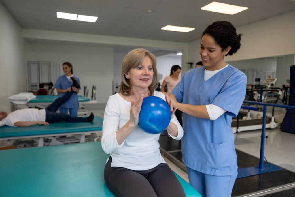 Senior woman exercising with a ball during physical therapy
