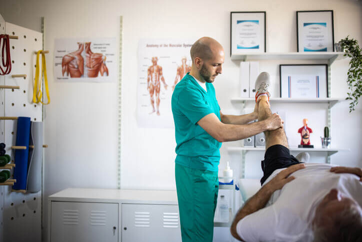 Physical therapist correcting the patient's posture