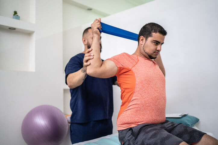 Man doing physical therapy exercises using a stretch band