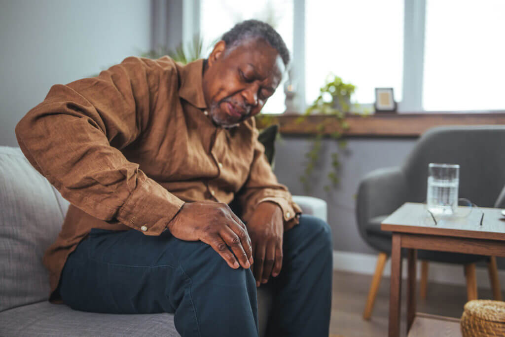 A mature man massaging his painful knee