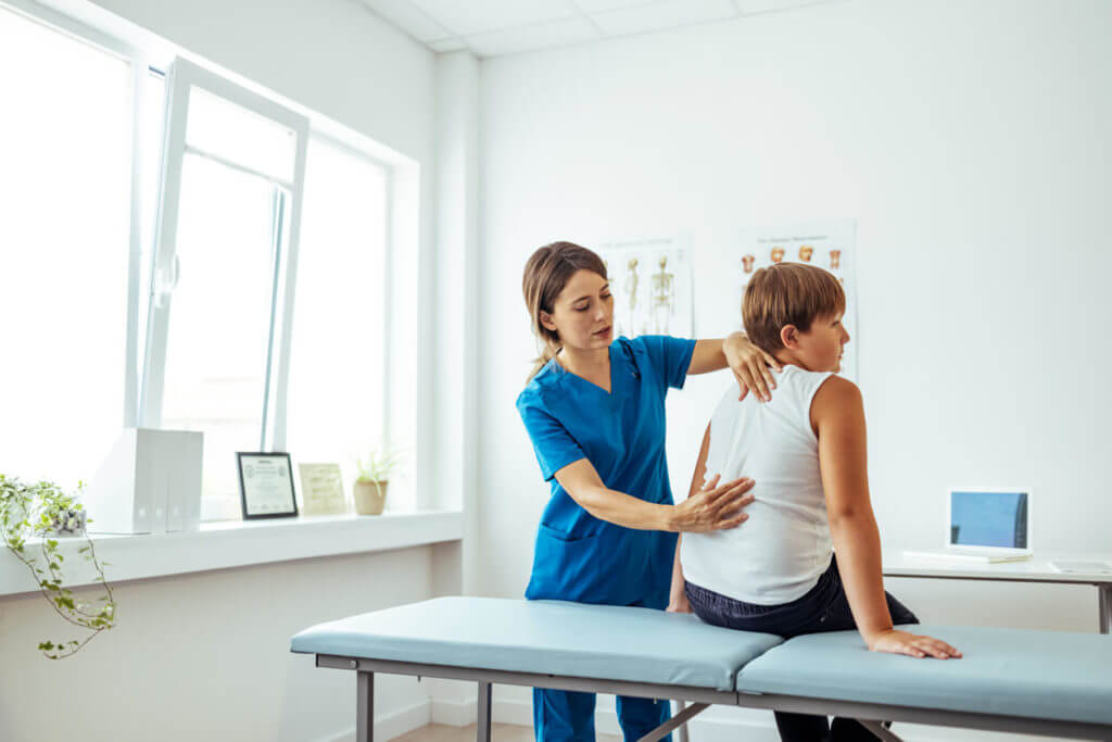 Young patient doing physiotherapy at a clinic with help of a therapist