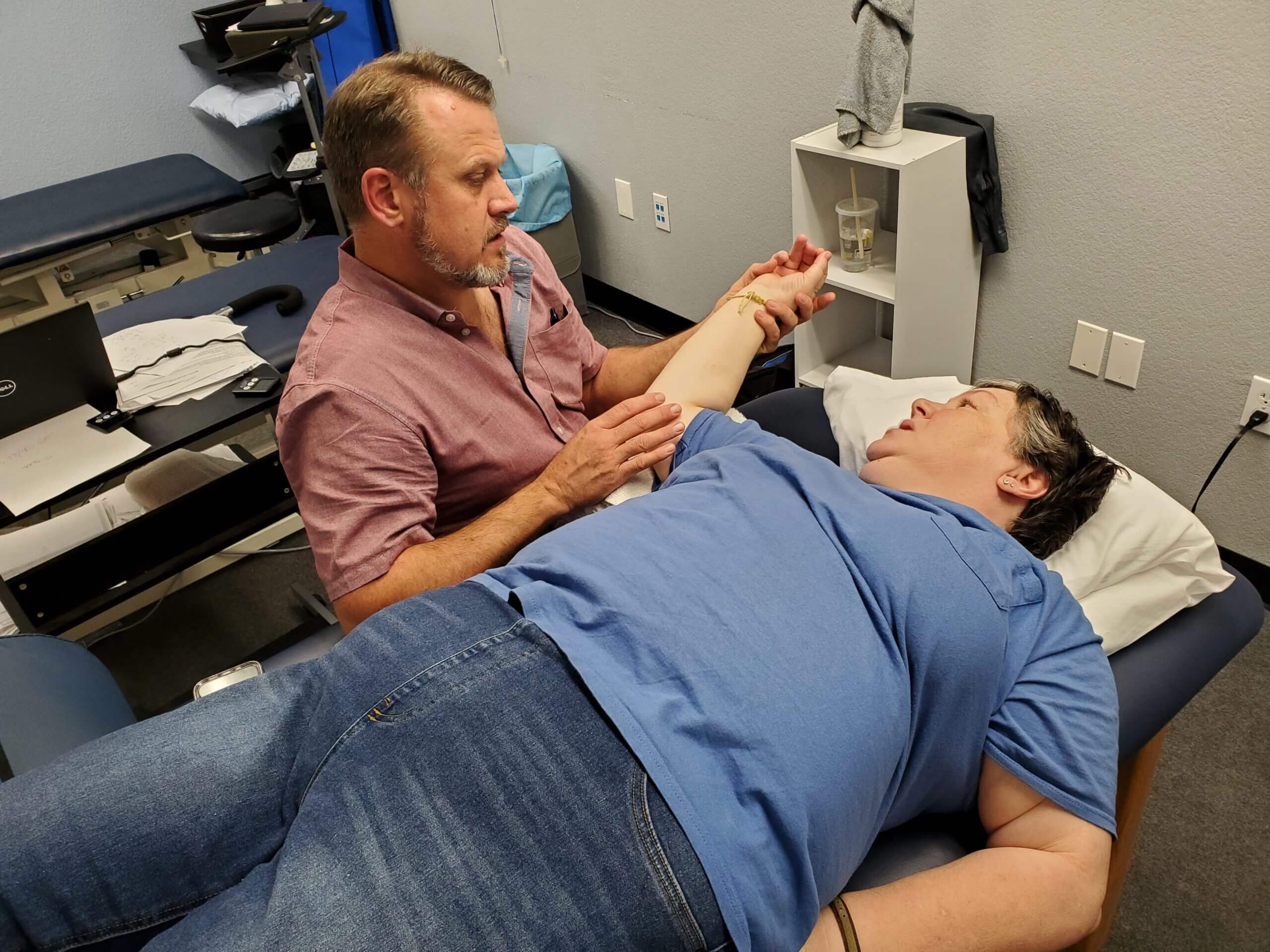 physical therapist exercising woman's arm 