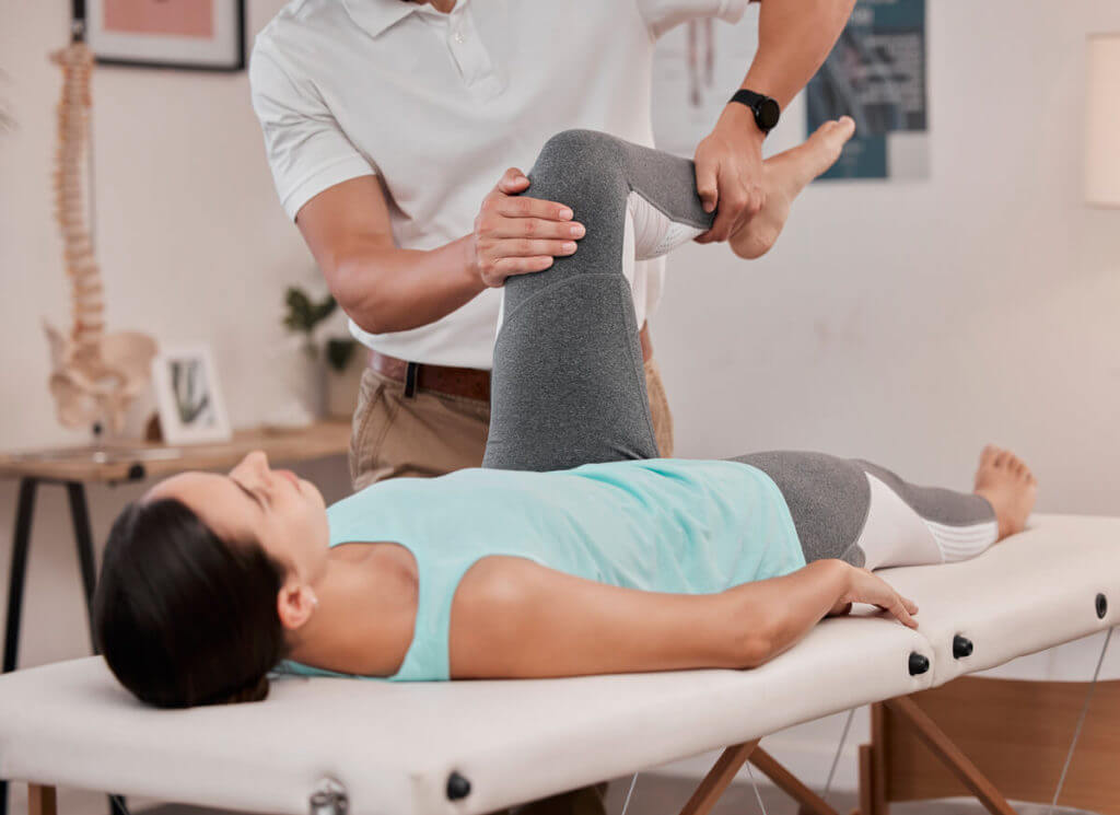 physical therapist stretching a patient's knee