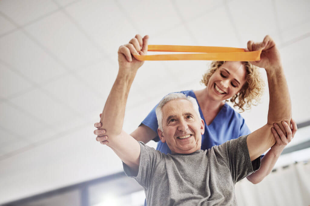 senior man exercisin with his physical therapist