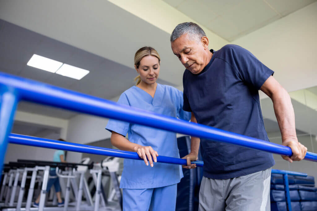 Man doing orthopedic physical therapy and walking on bars