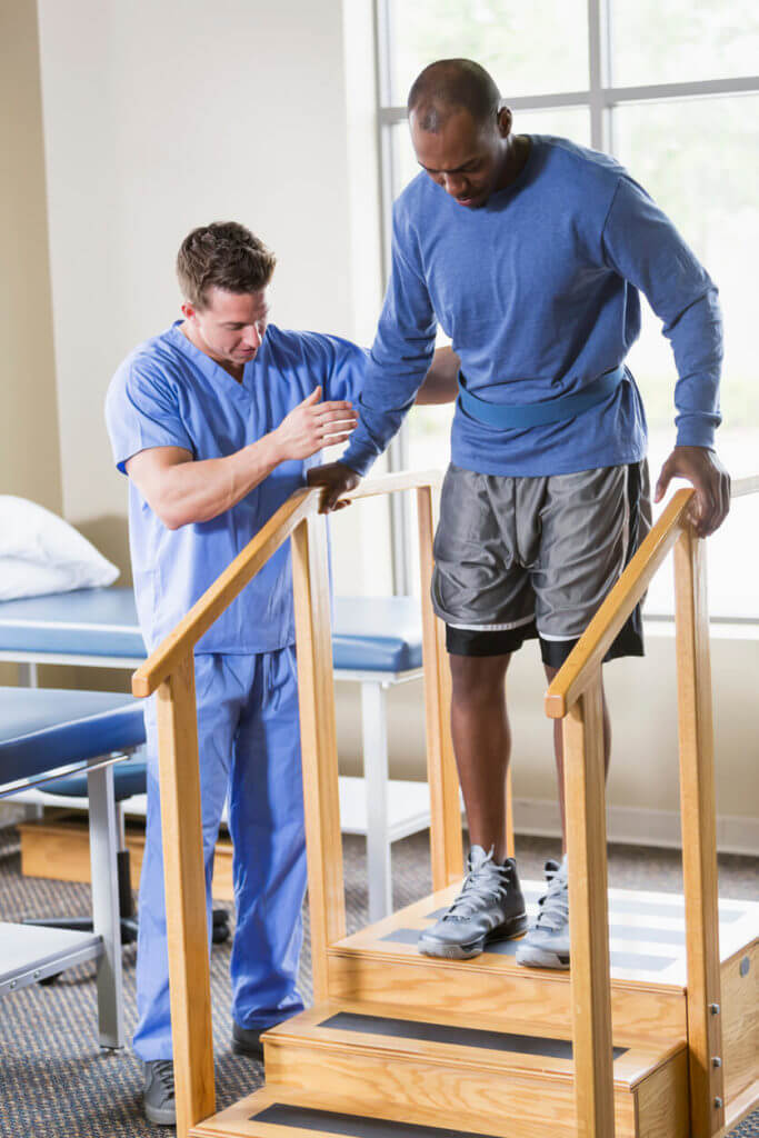 Orthopedic Physical therapist helping patient on stairs