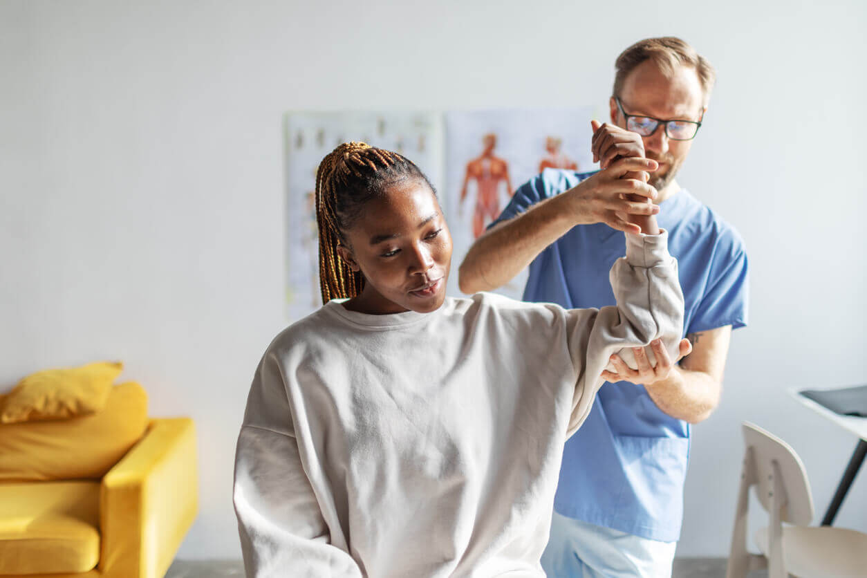 physical therapist and female patient with arm injury 