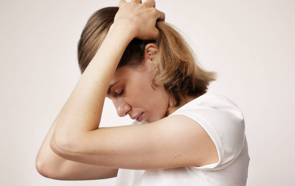 young blonde woman with migraine