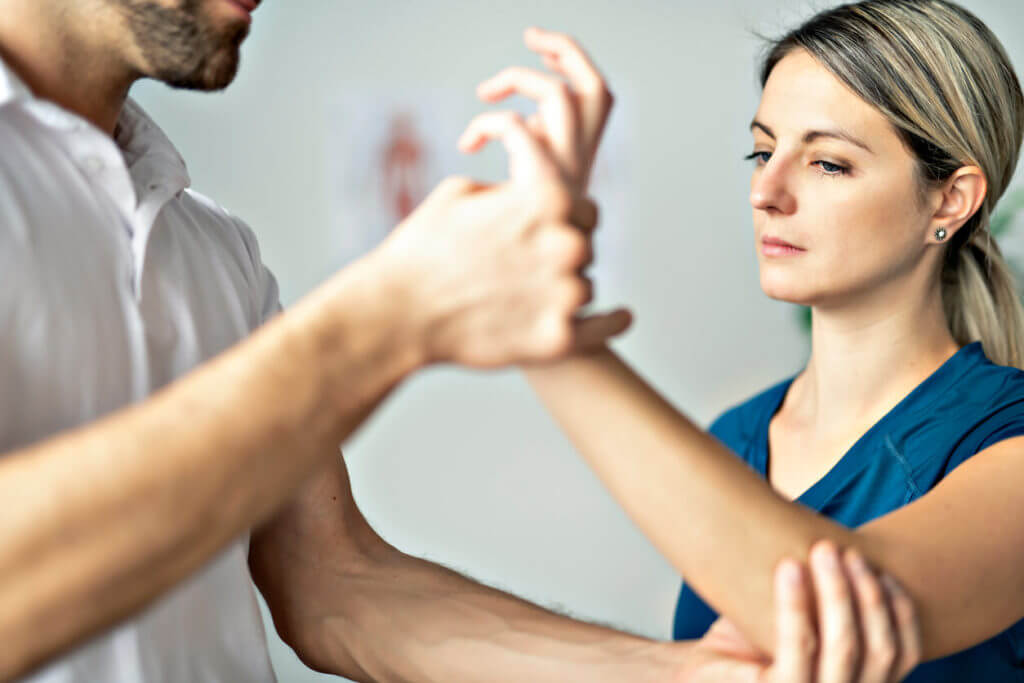A modern rehabilitation physiotherapist works with a female client during hand therapy.
