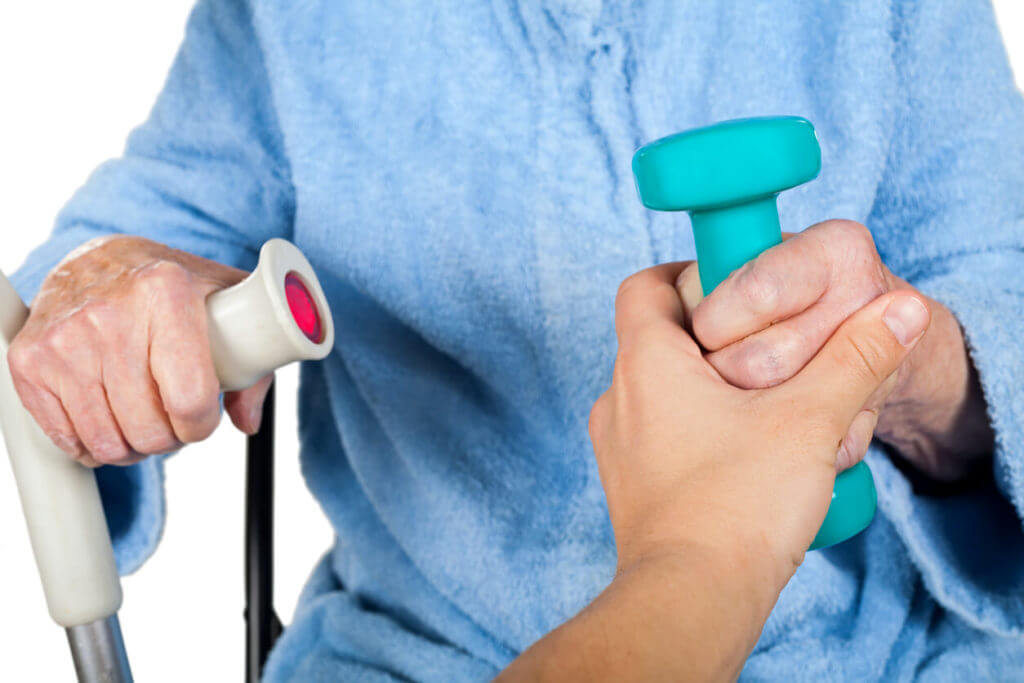 A senior woman is receiving occupational therapy as treatment for Parkinson's disease.